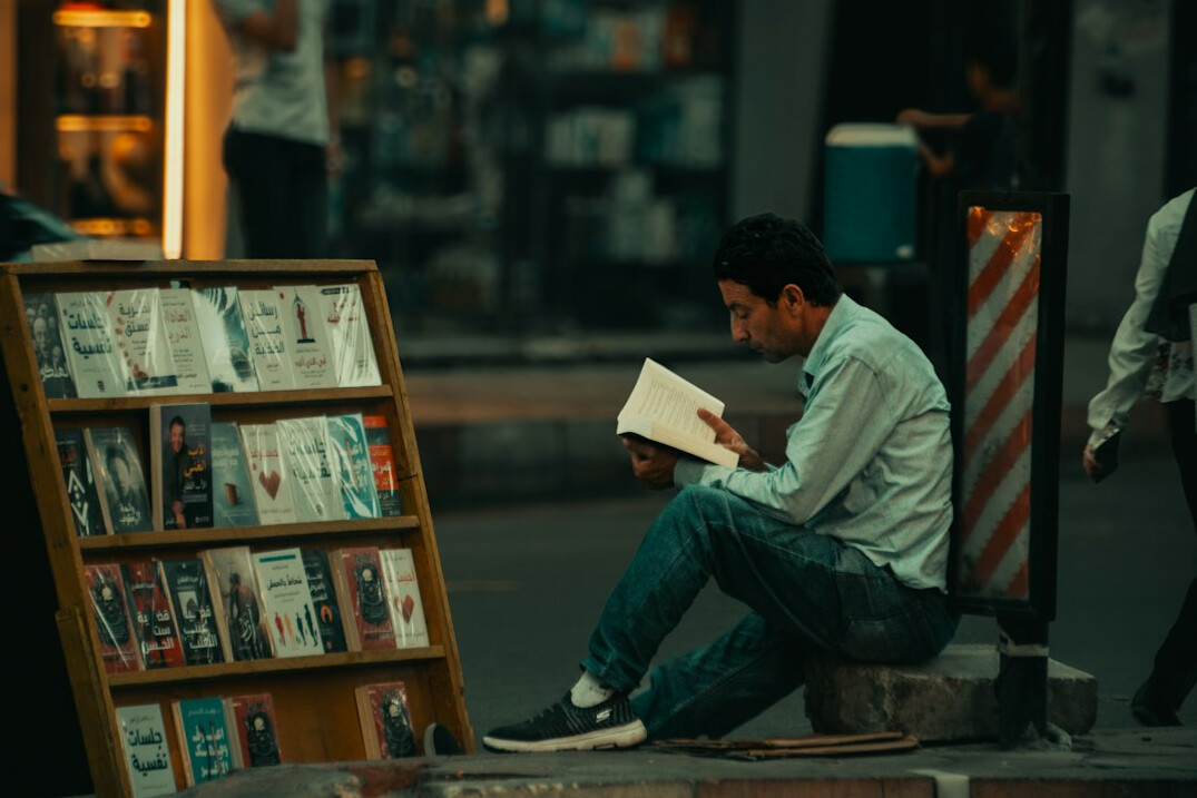person reading a book outdoors